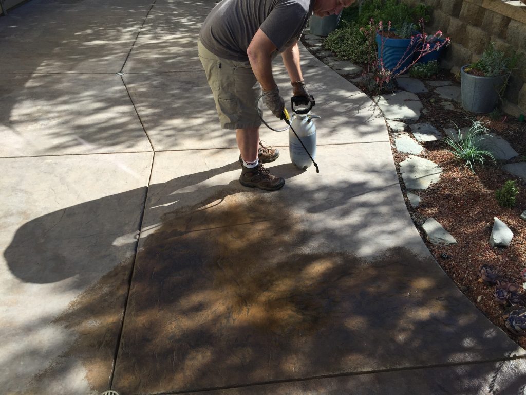 Applying Surecrete Ecostain to a concrete patio with a pump up sprayer