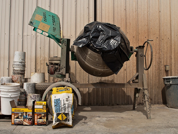 concrete mixer with trash bag over concrete mixer's opening