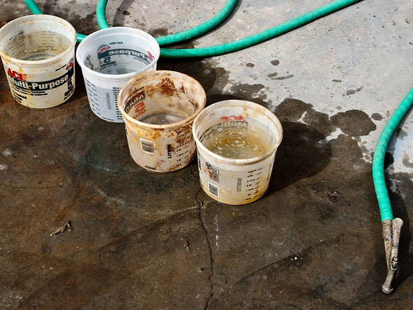 Buckets of water waiting to be poured into concrete mixer