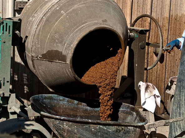 Wet concrete pouring out of concrete mixer